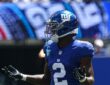 New York Giants cornerback Deonte Banks spreads his arms and gestures with both hands during a game.