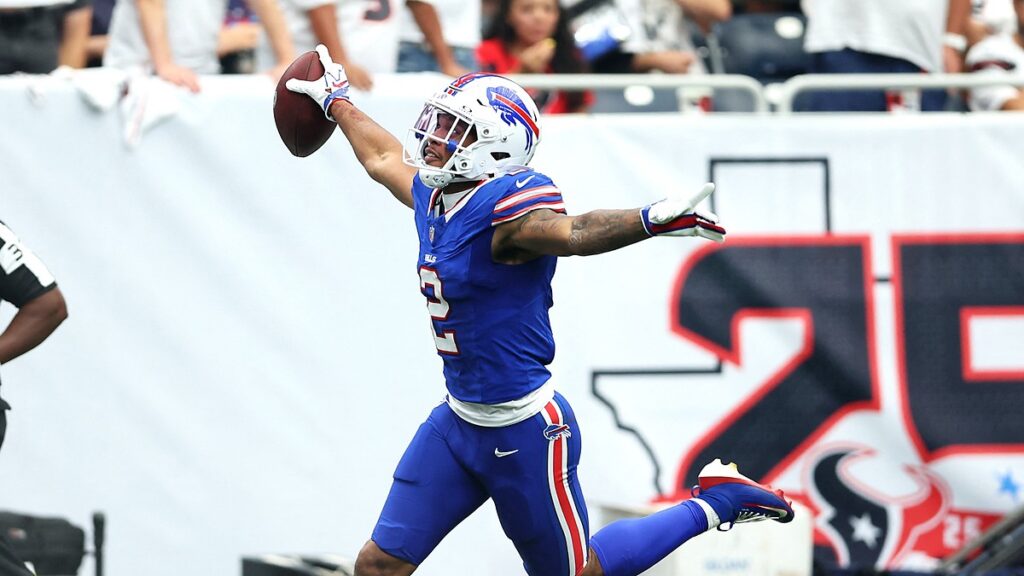 Buffalo Bills wide receiver DJ Moore holds the ball overhead with his arms spread after scoring a touchdown.