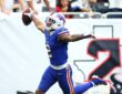 Buffalo Bills wide receiver DJ Moore holds the ball overhead with his arms spread after scoring a touchdown.