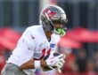 Tampa Bay Buccaneers wide receiver Jalen McMillan secures a pass in both hands during a training camp drill.