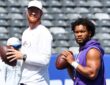 Minnesota Vikings quarterbacks Kyler Murray and Carson Wentz each hold a football as they warm up before a game.