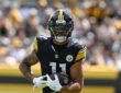 Pittsburgh Steelers wide receiver Michael Pittman Jr. runs upfield with the ball held in both hands.