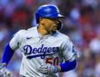 Los Angeles Dodgers shortstop Mookie Betts runs toward first base in his helmet and batting gloves.