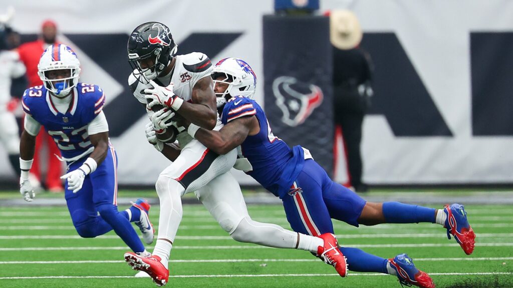 Houston Texans wide receiver Nico Collins holds the ball as Buffalo Bills cornerback Kani Walker wraps him up.