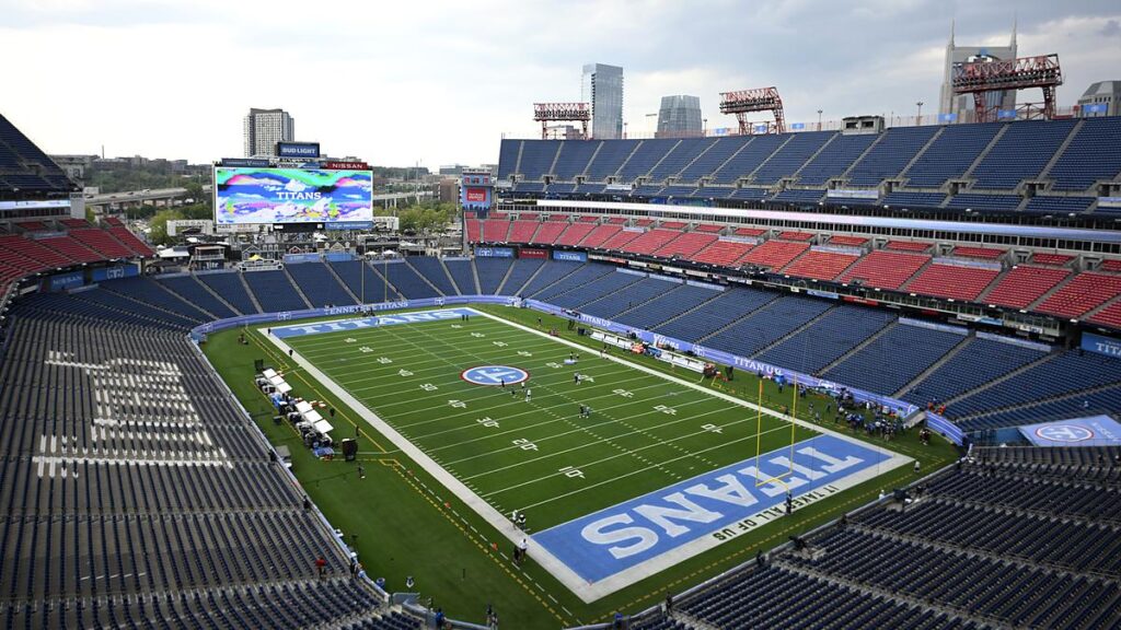 An elevated view of Nissan Stadium with empty seats and a few players on the field before kickoff.