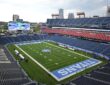 An elevated view of Nissan Stadium with empty seats and a few players on the field before kickoff.